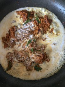 Adding coconut milk to the fried spice paste